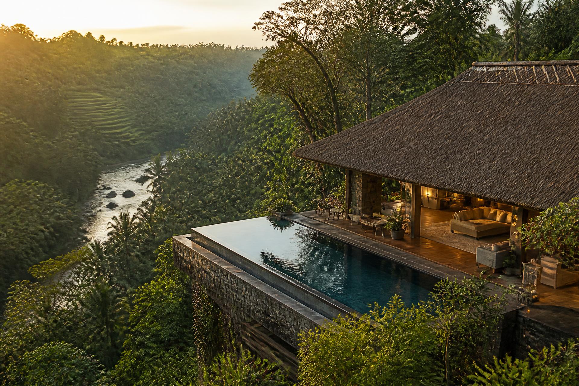 Wellness bungalow with thatched roof and infinity pool perched above the Ubud jungle canopy